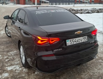 Қара Chevrolet Monza-ның артқы көрінісі, нөмір 554ADV15, қысқы ландшафттың фонында