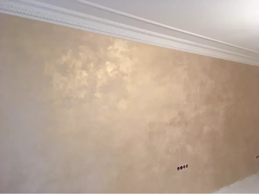 Человек, укладывающий пол в помещении на фоне обоев