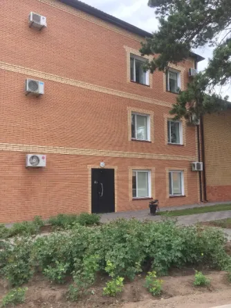 Фасад кирпичного здания с окнами и входной дверью