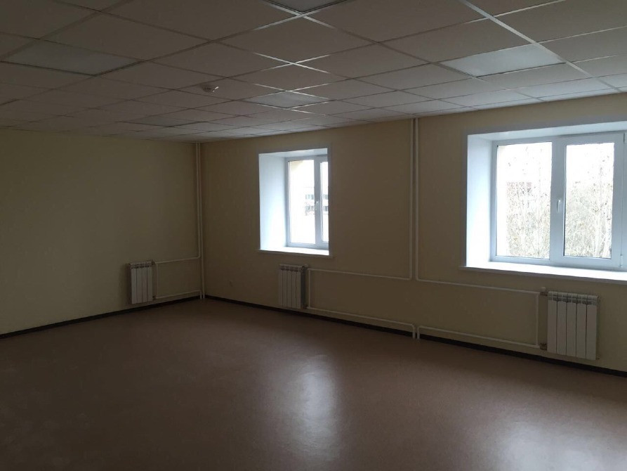 Пустое помещение с двумя окнами и радиаторами