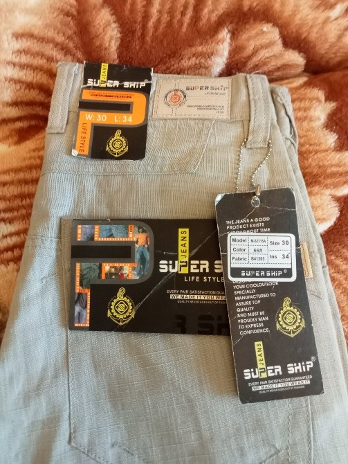 Артқы жағында джинсы, қара-көк түсті, егжей-тегжейлі қалталарымен және жапсырмасы бар