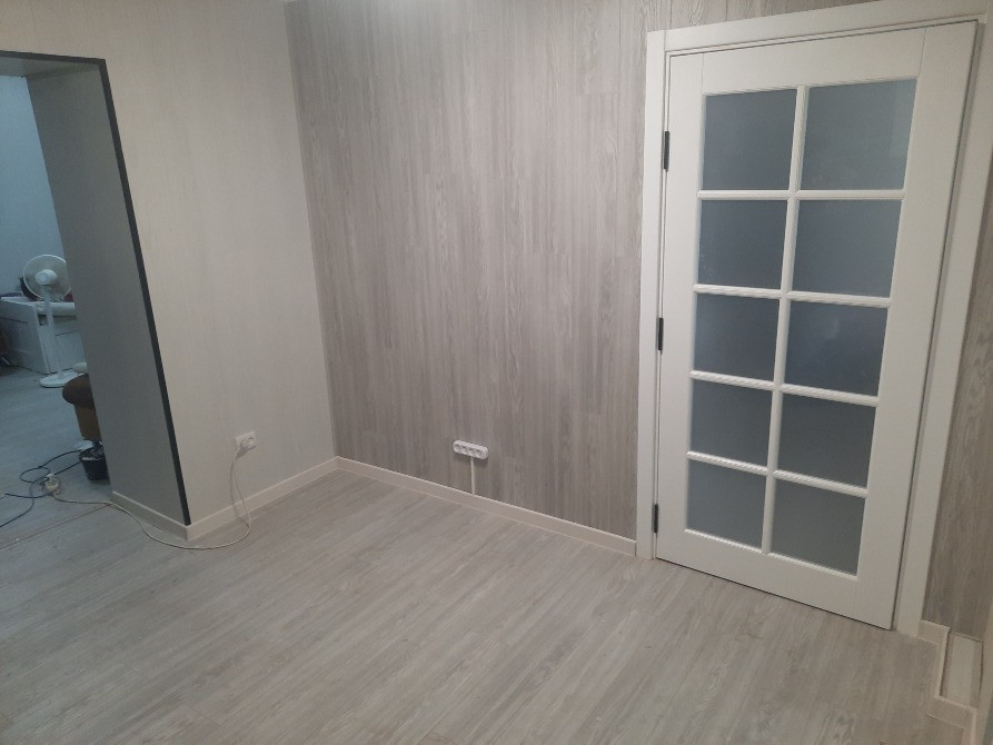 Современный интерьер комнаты с дверью и светлыми стенами