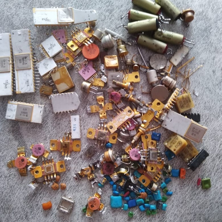 Большое количество радиодеталей и схем, разбросанных по поверхности