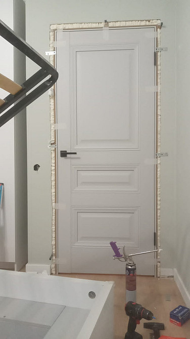 Орнатылу процесіндегі құлыпталатын есік, стриппингпен қоршалған