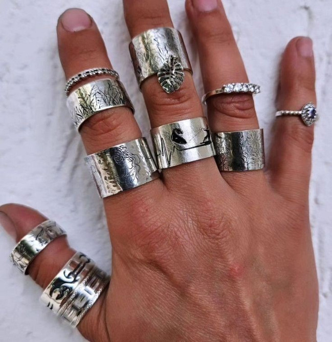 Коллекция серебряных колец на руке