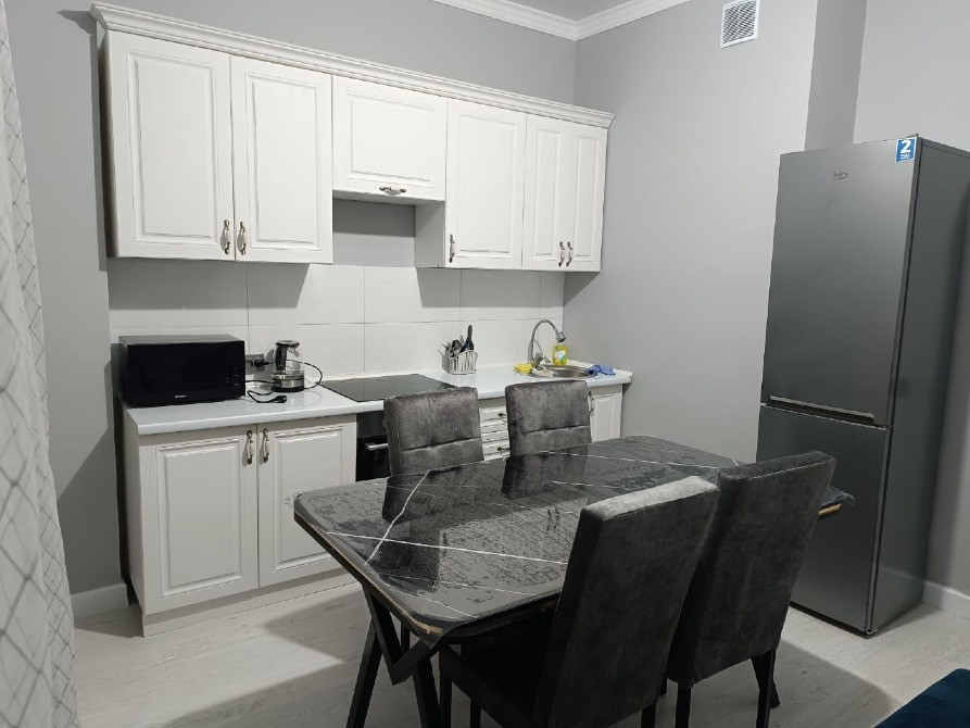 Заманауи асхана ас үстелі мен тоңазытқышпен