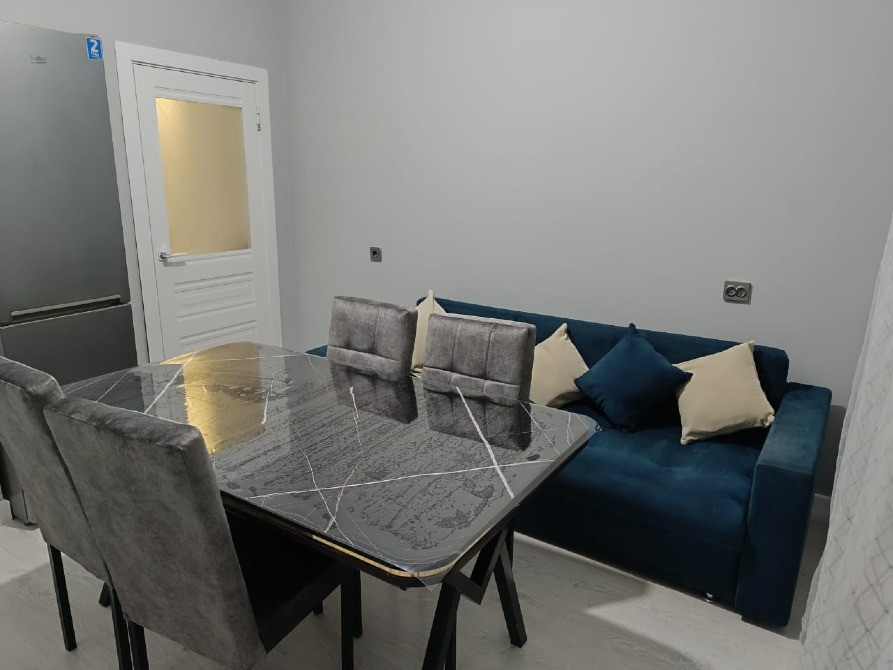 Ас үстелі мен диван қонақ бөлмесінде