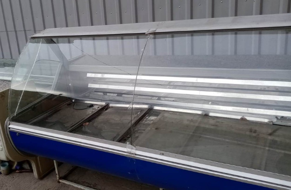 Продуктылар мен көк негізі бар подстакандары бар шыны витрина