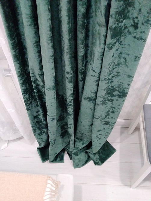 Крупный план зелёных бархатных штор, акцент на складки и текстуру ткани