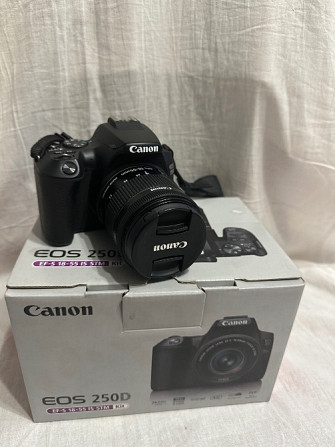 Canon EOS 250D камерасы қораптың фонында