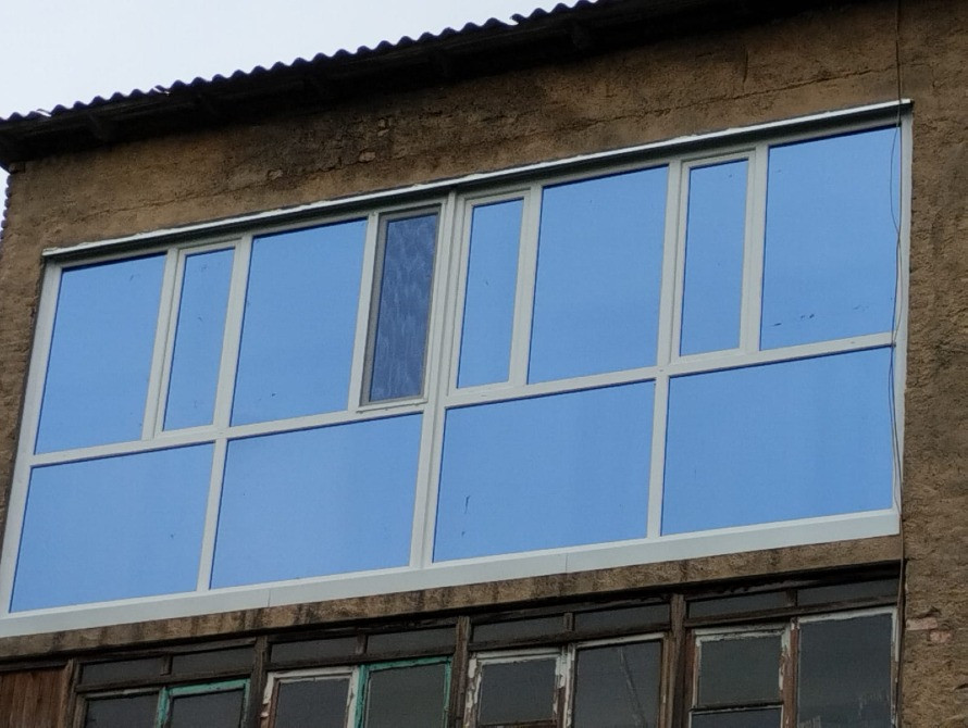 Фасад здания с большими окнами и голубым небом