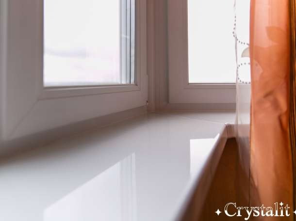 Чистый подоконник с занавеской оранжевого цвета и светлым окном