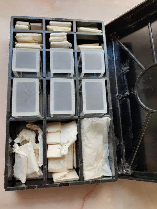 Ящик для хранения мелких предметов с разделителями, заполненный прозрачными контейнерами и упаковками