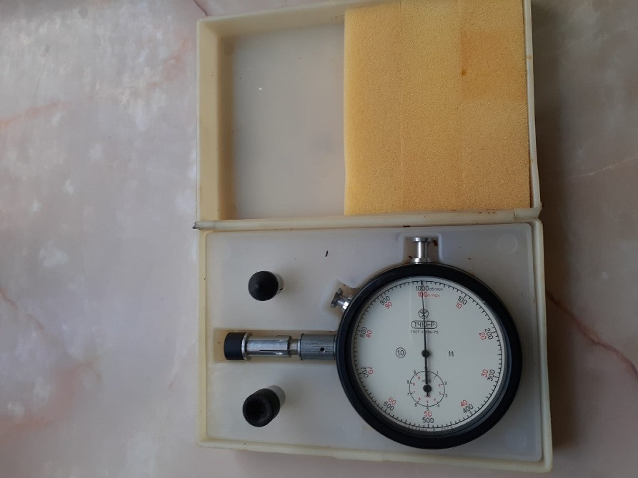 Часовой измерительный инструмент в коробке, показывающий шкалу и различные насадки