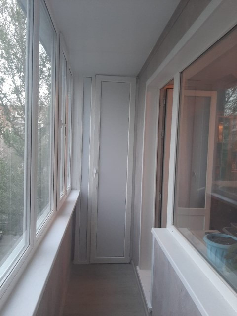 Балкон с большими окнами и белыми стенами