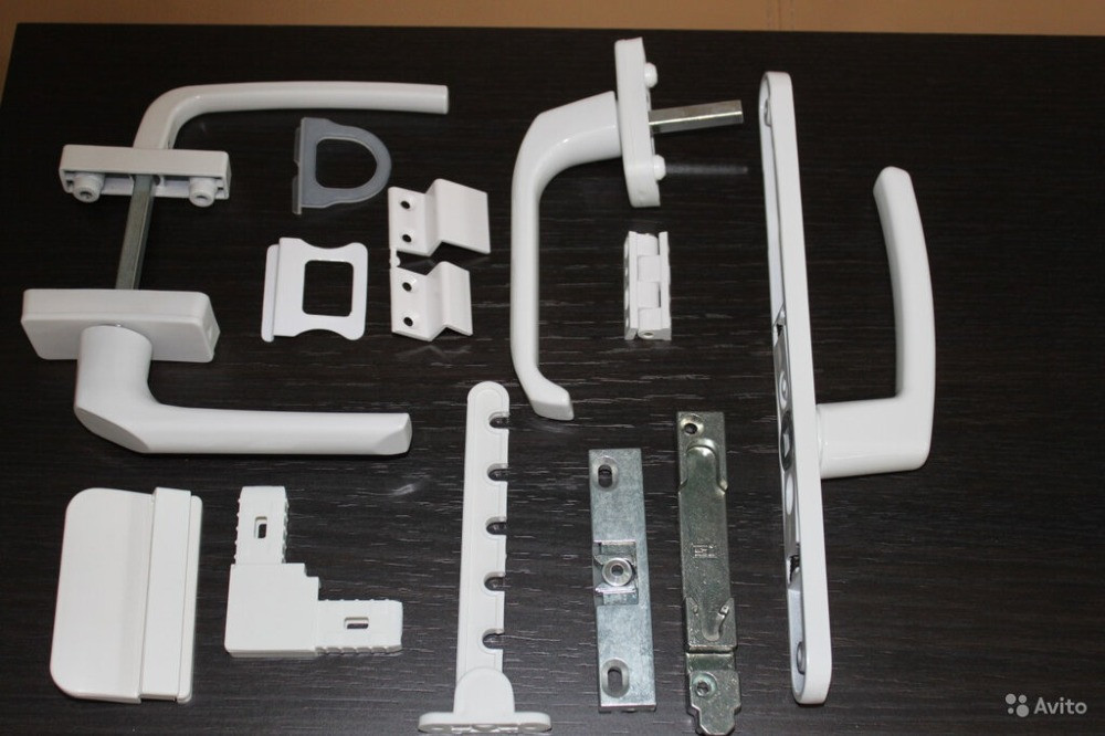 Есік пен терезе орнатуға арналған ақ элементтері бар есік тұтқалары мен фурнитура жиынтығы.