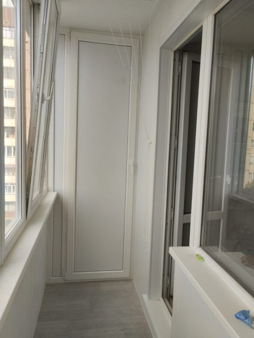 Просторный балкон с шкафом и панорамными окнами, современный дизайн