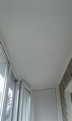 Потолок застекленной лоджии с гладкой поверхностью и окнами