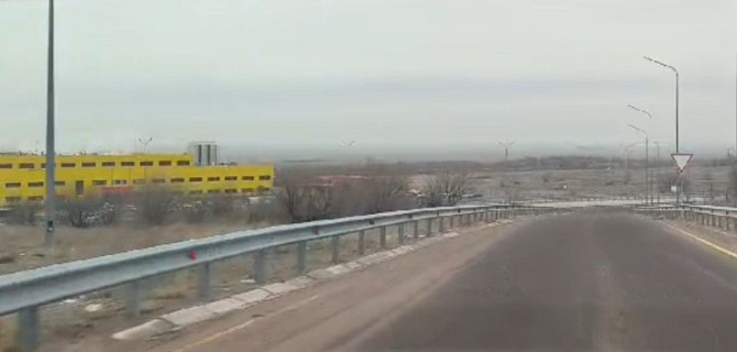 Дорога с видом на желтое производственное здание