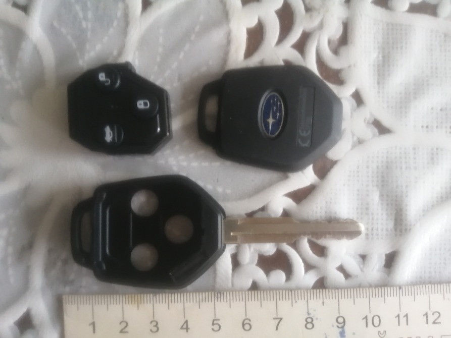 Субару автокөлігінің кілттері, кружевной матаның фонында