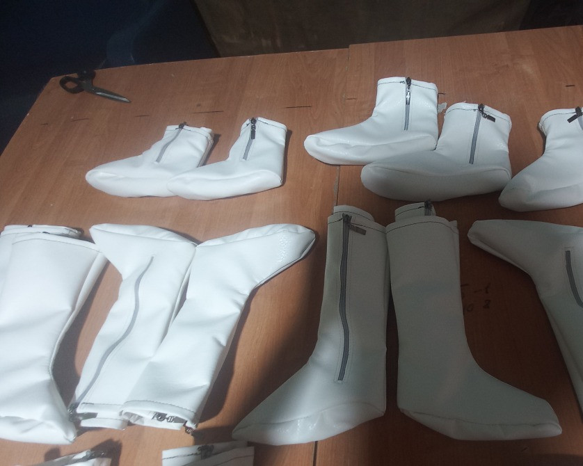 Әртүрлі формадағы ақ ботинкалар үстелде
