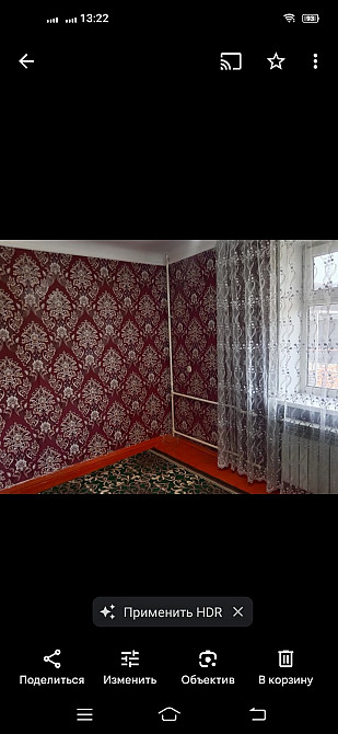 Комната с красными обоями и ковром на деревянном полу