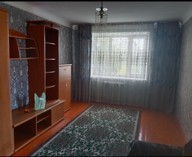 Гостиная с мебелью, ковром и большим окном