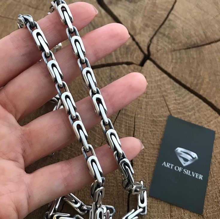 Цепочка из серебра в руке с логотипом 