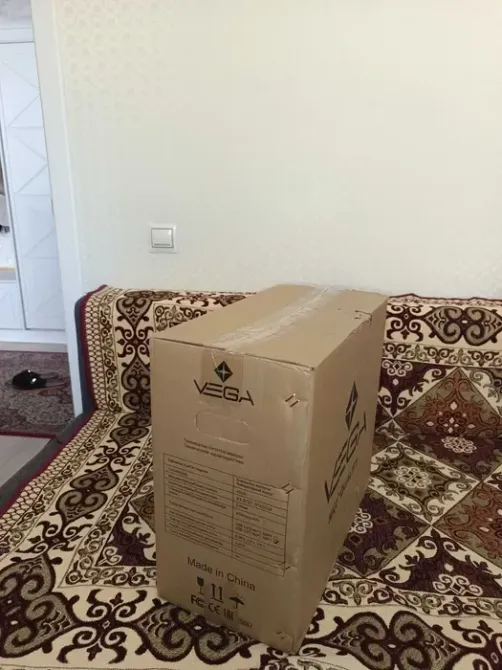 Упаковка компьютерного корпуса на диване с декоративной тканью