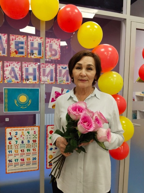 Розалармен безендірілген әйел, мерекелік сәндеулер мен шарлар фонында.