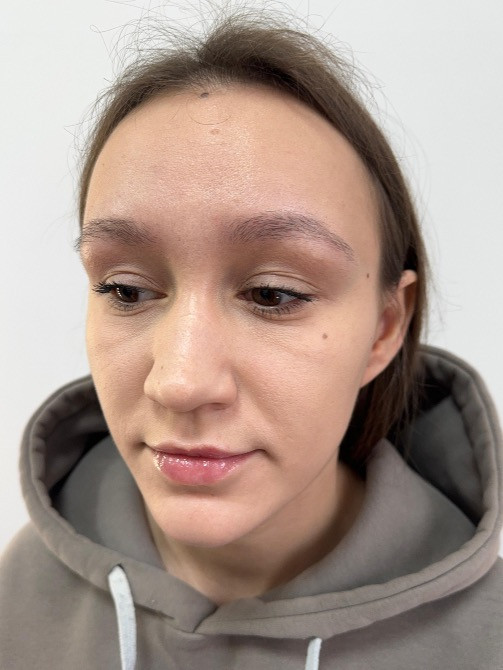 Макияжды бетінде бар қыздың портреті, ол алға қарай қарап отыр