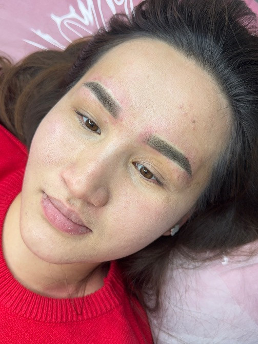 Қызыл свитердегі қыз, кушеткеде жатып, жеңіл макияжбен және әдемі модификацияланған қастармен