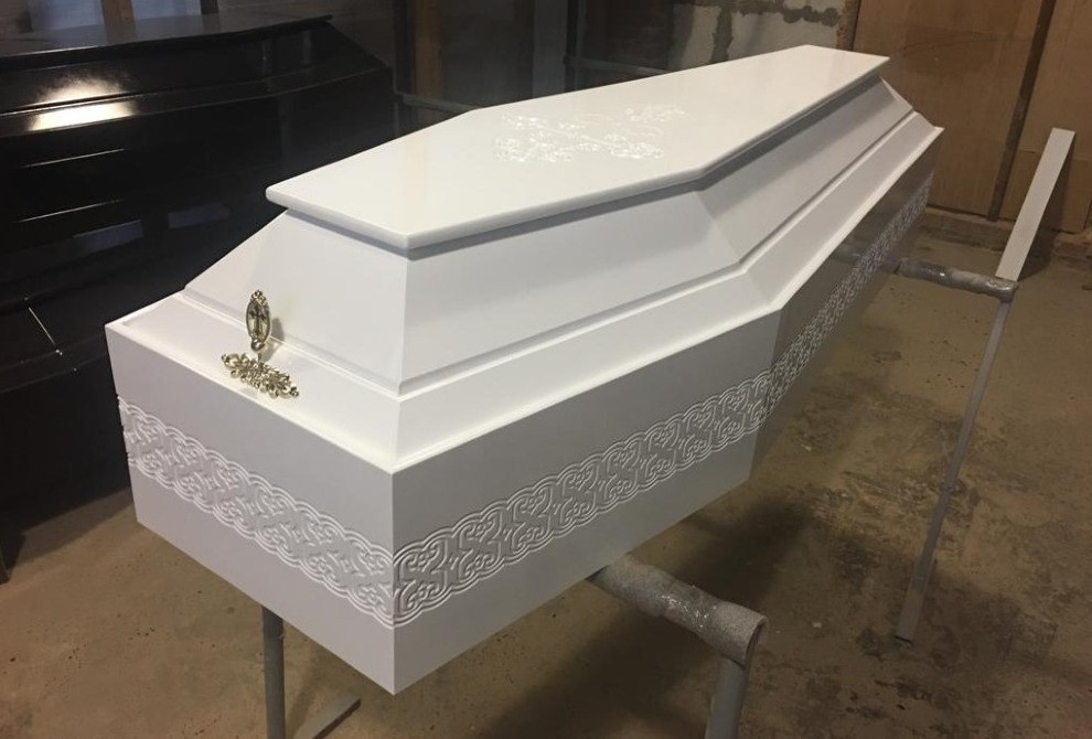 Белый гроб с декоративными элементами, выполненный с особым искусством