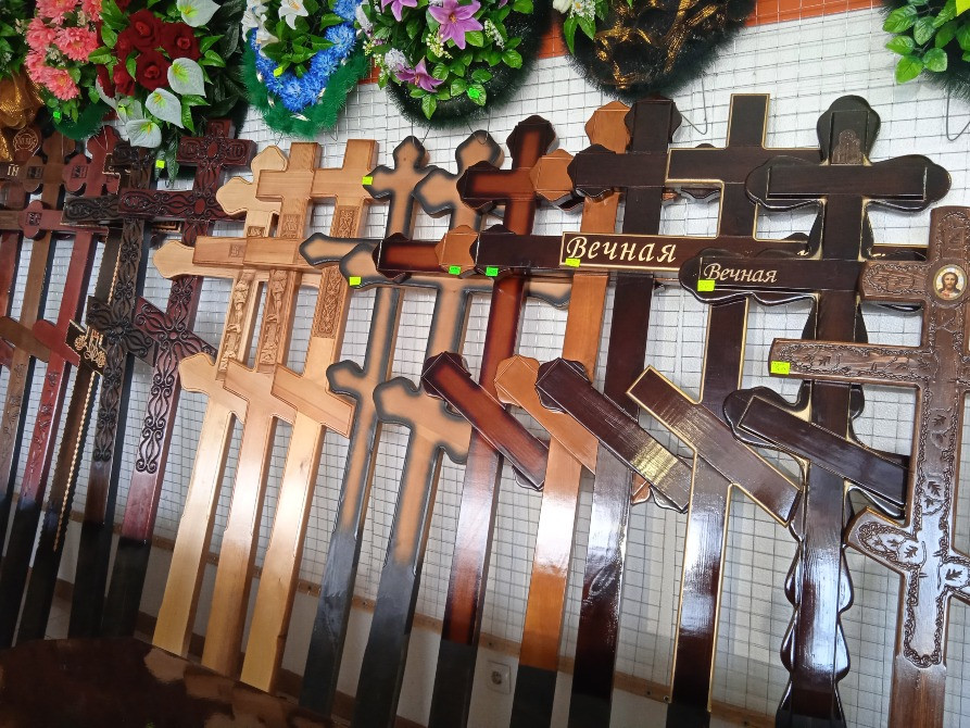 Разнообразные деревянные кресты разных размеров и дизайнов на стене магазина