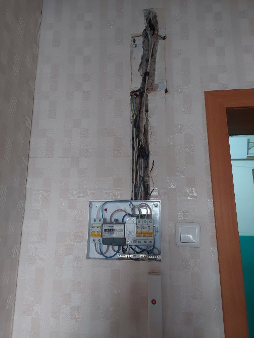 Зақымдалған сымдары бар қабырғаға орнатылған электр панелі