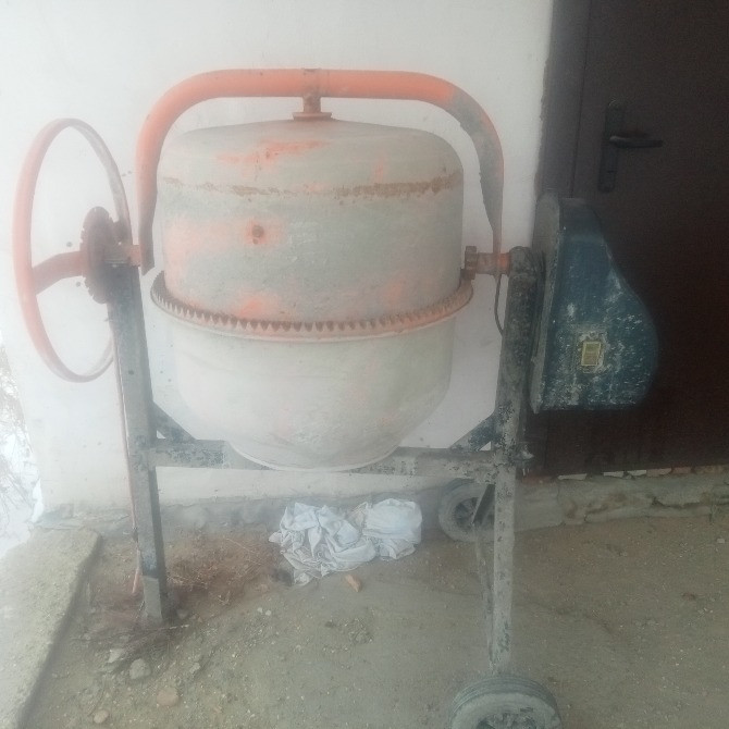 Ескі бетон араластырғыш құрылыс алаңында лас корпус пен тот басқан бөлшектермен.