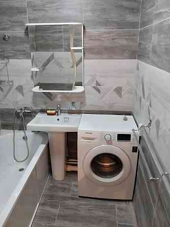 Заманауи стильдегі ванна бөлмесі туалет, раковина және ваннамен