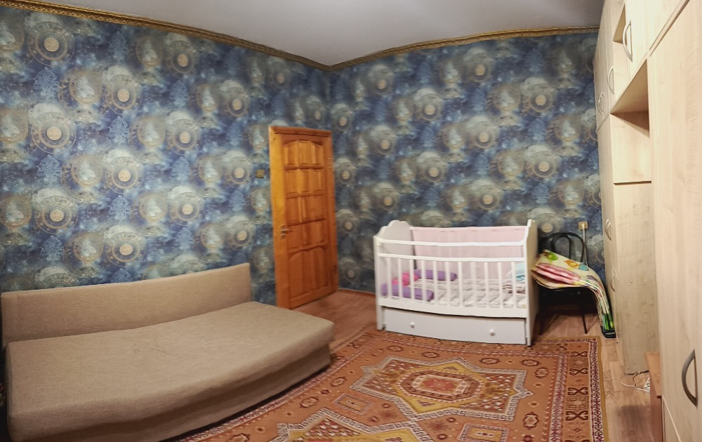 Комната с детской кроваткой и диваном