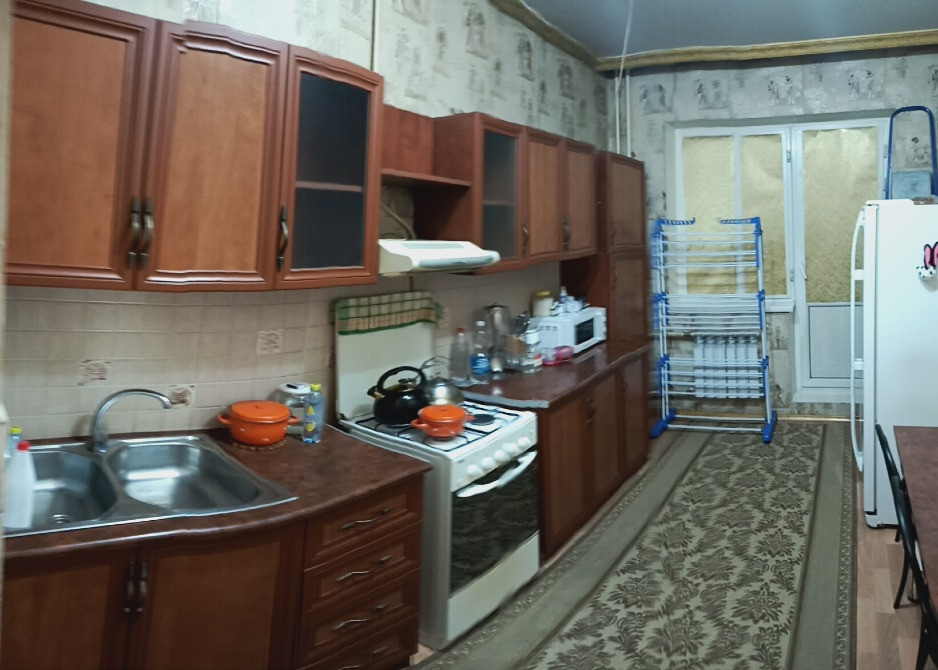 Кухня с кухонными шкафами, плитой и бытовой техникой