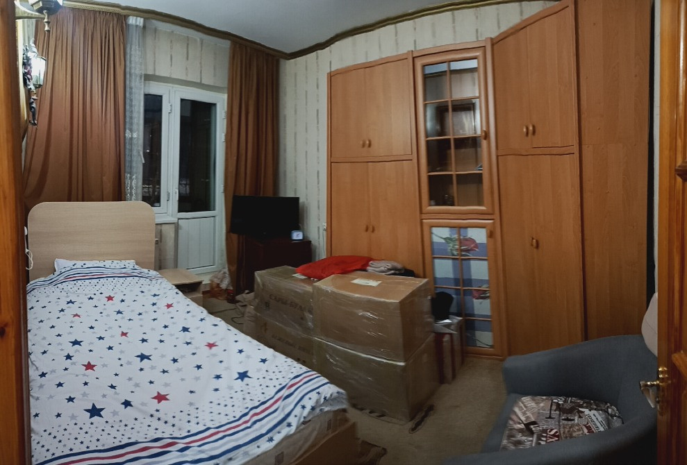 Спальня с кроватью, телевизором и мебелью