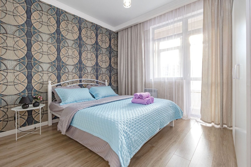 Спальня с двуспальной кроватью и декоративными стенами