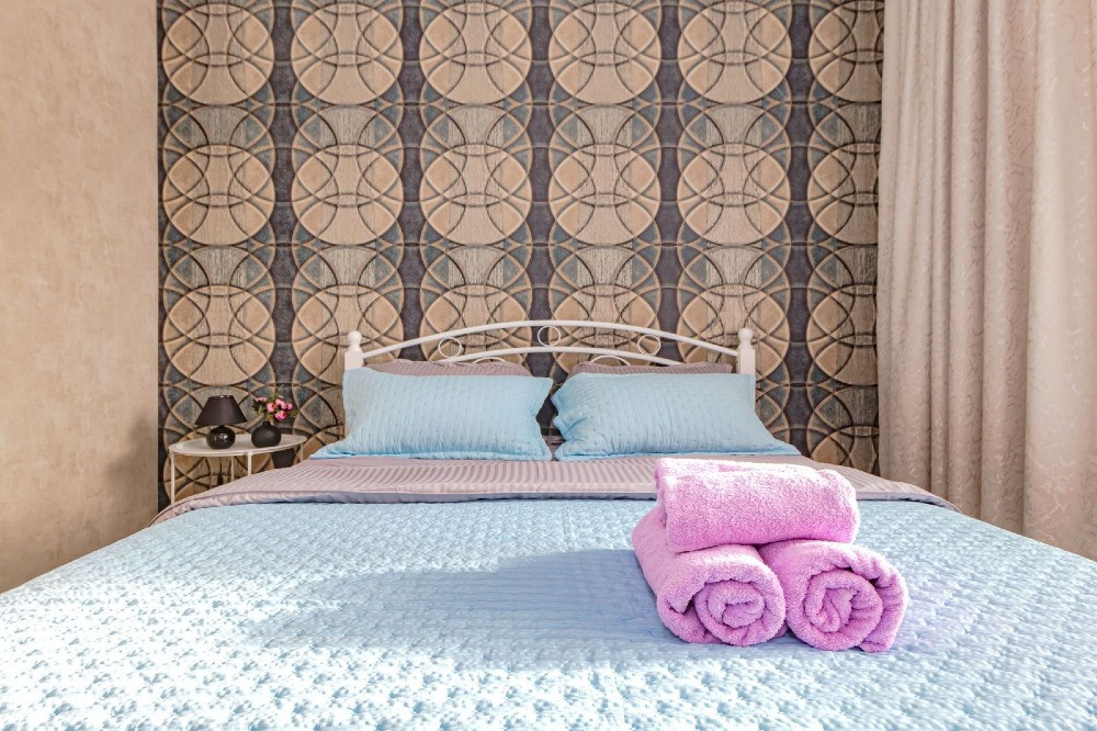 Кровать с постельным бельем и полотенцами