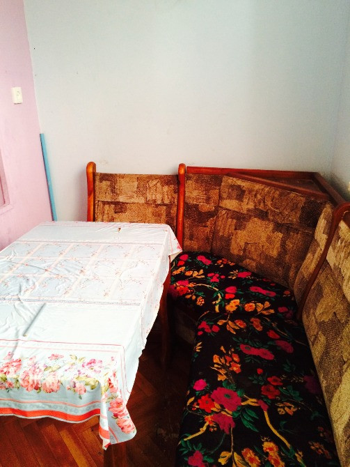 Гүлдө боянған қаптамасы бар үстел мен орындықтары бар асхана аймағы