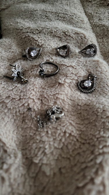 Изображение различных серебряных украшений на мягкой поверхности