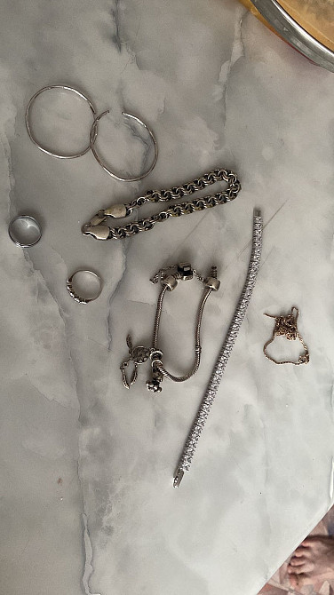 Изображение коллекции серебряных украшений на мраморной столешнице