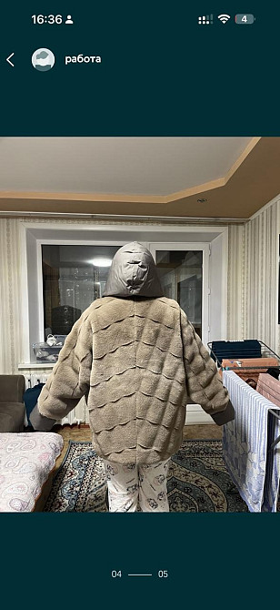 Мужчина в теплой одежде стоит с поднятыми руками в комнате