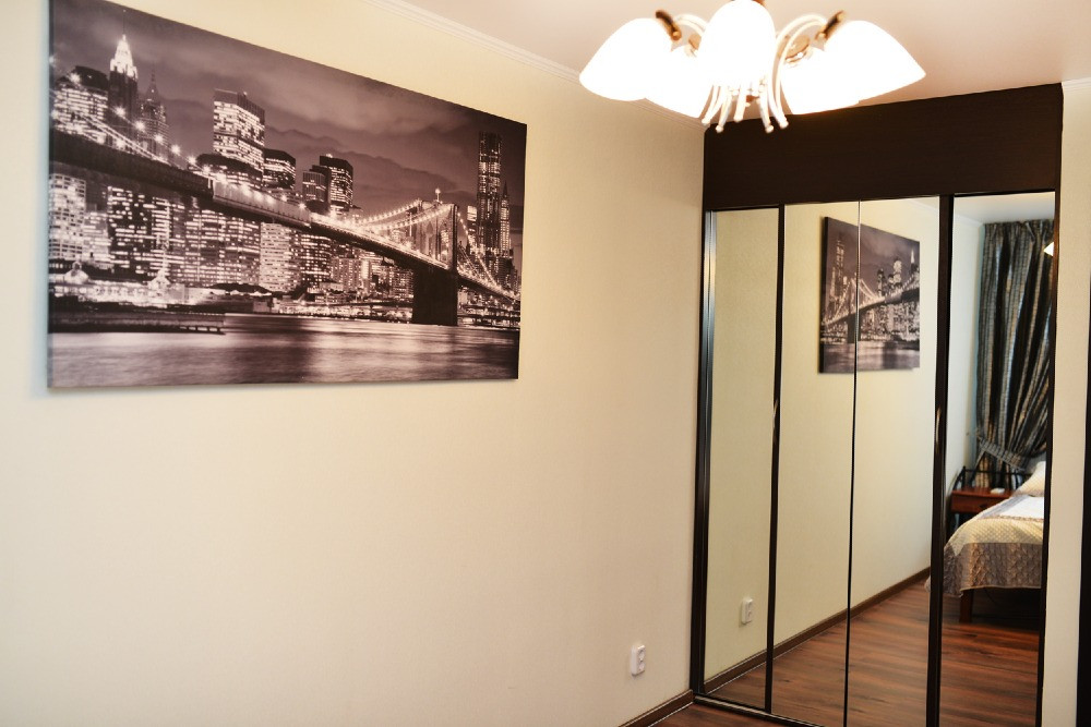 Зеркало и фотография на стене в спальне