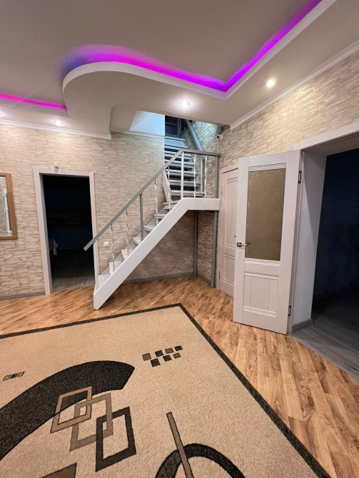 просторный коридор с лестницей и современным освещением