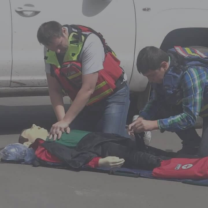 Екі адам манекенге алғашқы медициналық көмек көрсету жаттығуын өткізуде