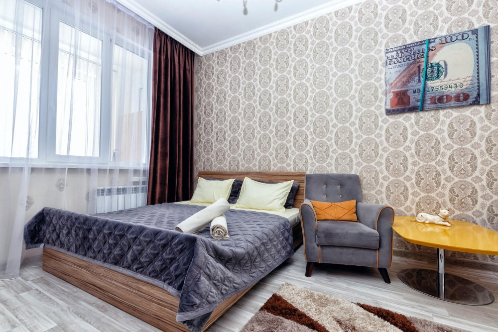 Уютная спальня с двумя креслами и кроватью